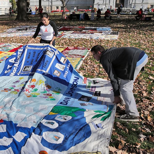 Nina Martinez (left), an AIDS advocate, and Roddy Williams, AIDS Quilt director of operations, straighten a section of the AIDS Quilt last December at Emory University. (Bob Andres/AJC)