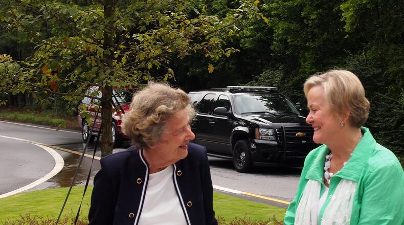 Sandy Springs Mayor Eva Galambos (left) sits in front of an oak tree planted in a pocket park dedicated to her by the Sandy Springs Society. Valerie Love (right), a former society president, came up with the idea as a way to honor the mayor and promote one of the group's goals - beautifying the area. Photo conrtibuted by J. Johnson.