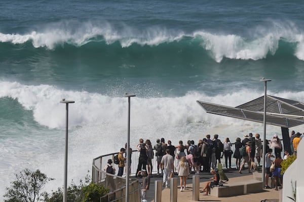 People watch as large swells hit Sydney's Bondi Beach Wednesday, April 2, 2025. (AP Photo/Mark Baker)
