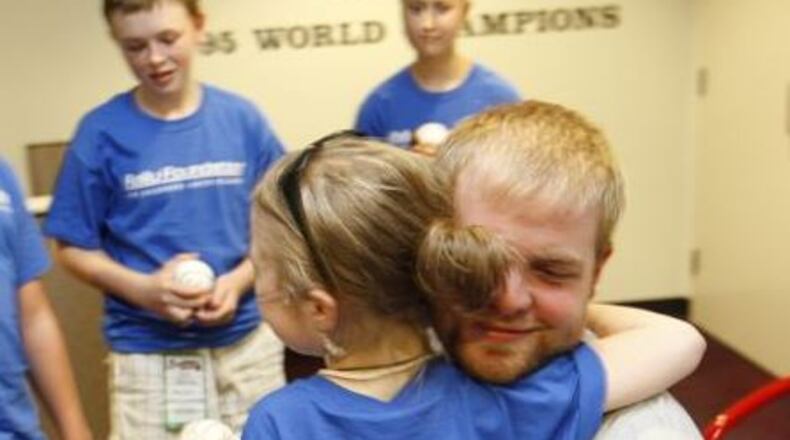 Brian McCann hugs nine-year-old Alexa Rohrbach in the Braves clubhouse during the 2007 season. (Photo/ Rally Foundation)
