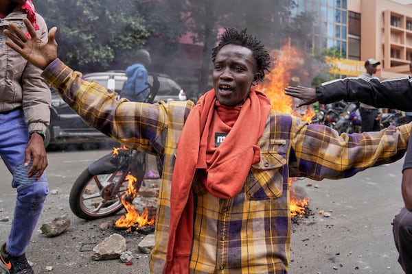 A protester gestures as police fire teargas at them during a demonstration over the death of blogger Albert Ojwang in police custody, in downtown Nairobi, Kenya, Tuesday, June 17, 2025. (AP Photo/Brian Inganga)