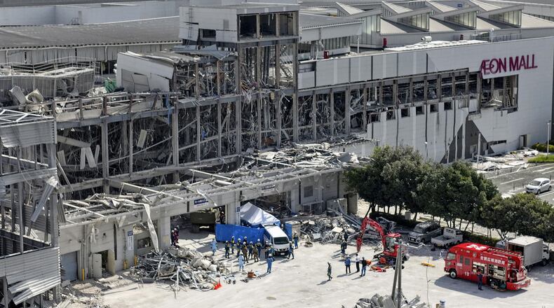 In this aerial image taken with a drone, responders work outside AEON Mall Kumamoto after an explosion occurred following an earthquake, in Kashima, Kumamoto Prefecture, southern Japan, Thursday, July 30, 2026. (Koji Harada/Kyodo News via AP)