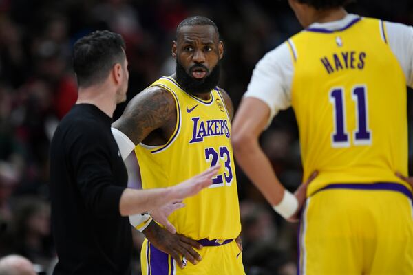 Los Angeles Lakers' LeBron James (23) talks with head coach JJ Redick left, during the second half of an NBA basketball game against the Chicago Bulls Thursday, March 27, 2025, in Chicago. (AP Photo/Paul Beaty)