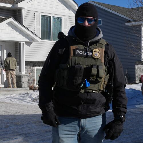 Federal agents knock on a door of a residence on Wednesday, Jan. 28, 2026, in Blaine, Minn. (AP Photo/Adam Gray)