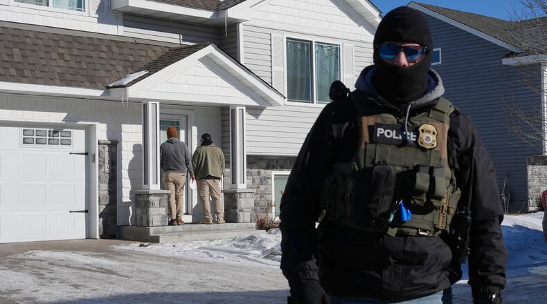 Federal agents knock on a door of a residence on Wednesday, Jan. 28, 2026, in Blaine, Minn. (AP Photo/Adam Gray)