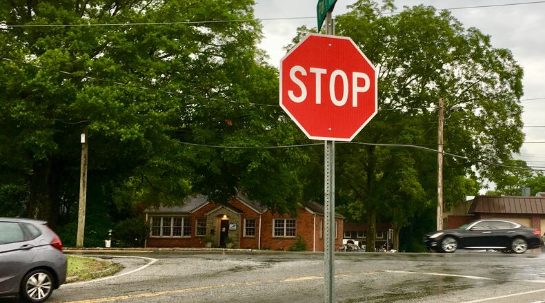Avondale Estates is once again considering building a roundabout at this intersection of Laredo Drive and Clarendon Road (where the car’s traveling right to left). City consultants who’ve studied a potential project for this site have said that under no circumstances would a roundabout, or any rebuilding of this intersection, affect the large Oak tree seen here to the left. Bill Banks for the AJC