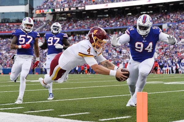 Washington quarterback Taylor Heinicke dives past Buffalo's Vernon Butler for a touchdown as the Bills' A.J. Epenesa (57) and Mario Addison (97) watch. In 2020, Epenesa was the rage until he ran a 5.04 in the 40-yard dash at the combine. He went 54th to Buffalo in the second round. (AP Photo/Adrian Kraus)