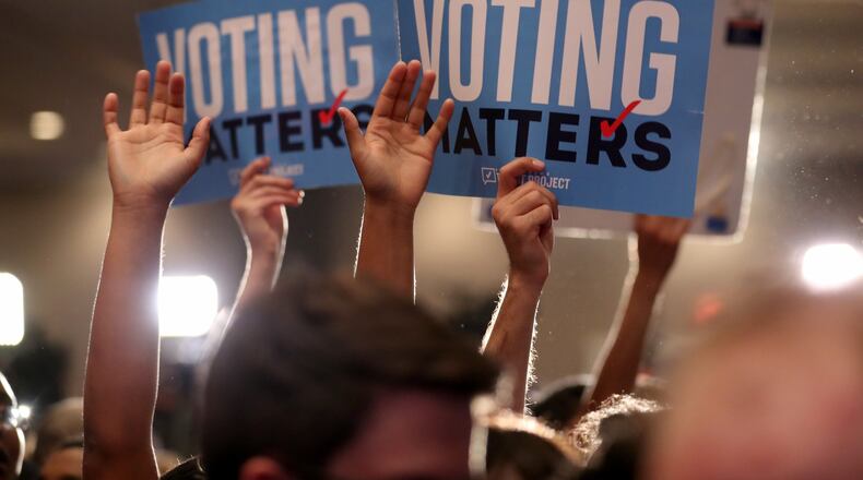 Jon Ossoff supporters hold Voting Matters signs in June 2017 in Atlanta. Their candidate lost the 6th Congressional District runoff -- but it was close, which is highly unusual in Georgia. JASON GETZ / AJC