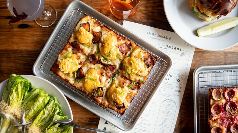 Emmy Squared offers Detroit-style pizza such as the Shed pizza (center) and Colony Squared pizza (lower right), plus items like Le Big Matt burger (upper right) and Caesar salad (lower left) and cocktails. Mia Yakel for The AJC