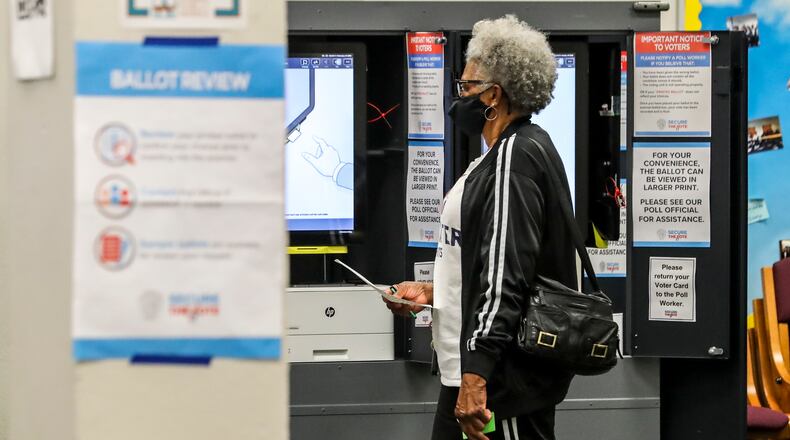Dorothy Stinchcomb takes her ballot to be tabulated at South Atlanta High School during Georgia's primary in May. (John Spink / John.Spink@ajc.com)