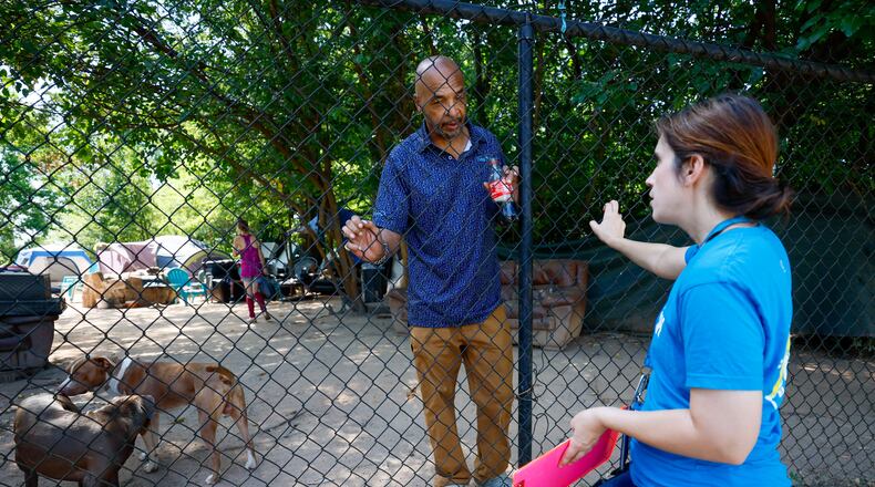 Tracy Woodard from InTown Cares, an outreach group that serves people experiencing homelessness in metro Atlanta, speaks with a Cooper Street encampment resident, Willie Jeffries, 60, on Monday, Aug. 12, 2024, in Atlanta. (Miguel Martinez / AJC)