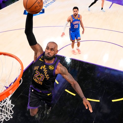 Los Angeles Lakers forward LeBron James, center, goes up for a dunk as Oklahoma City Thunder guard Luguentz Dort, left, and guard Ajay Mitchell watch during the second half of Game 4 in a second-round NBA basketball playoffs series Monday, May 11, 2026, in Los Angeles. (AP Photo/Mark J. Terrill)