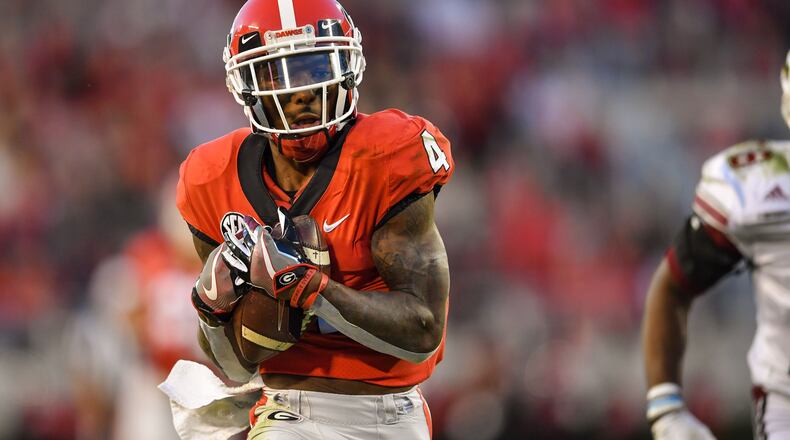 Georgia Bulldogs wide receiver Mecole Hardman (4) catches a touchdown pass behind Massachusetts Minutemen cornerback Justin Lewis (28) during the first half at Sanford Stadium.