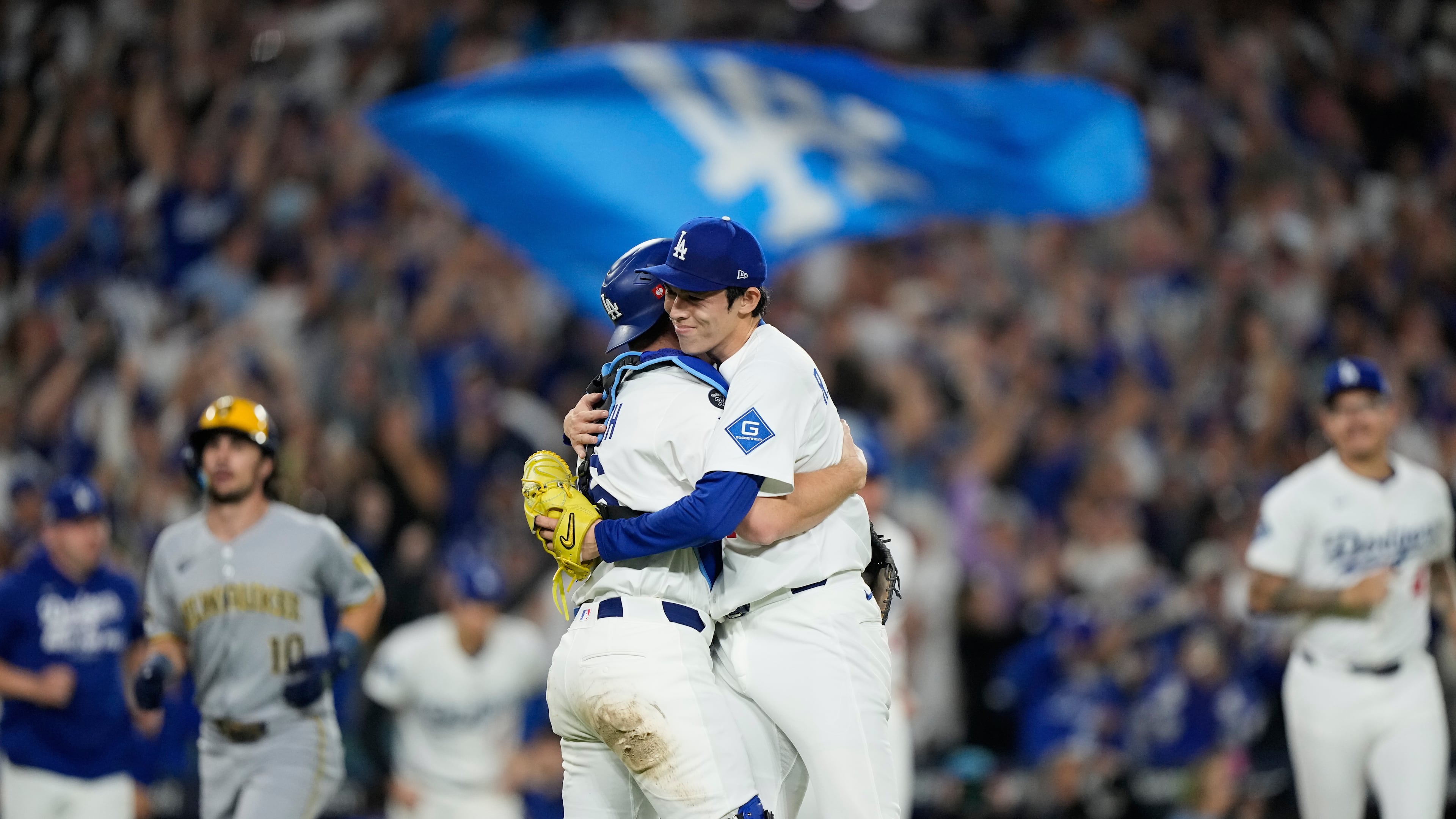 Los Angeles Dodgers pitcher Roki Sasaki and catcher Will Smith celebrates their win against the Milwaukee Brewers in Game 4 of baseball's National League Championship Series, Friday, Oct. 17, 2025, in Los Angeles. (AP Photo/Brynn Anderson)