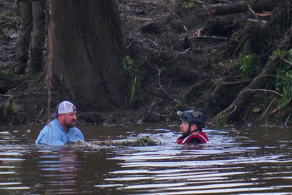 Officials are seen in the Guadalupe River as they assist in recovery efforts after a flash flood swept through the area Sunday, July 6, 2025, in Hunt, Texas. (AP Photo/Julio Cortez)