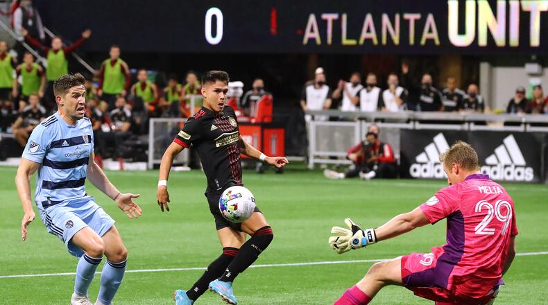 022722 : Atlanta United attacker Luiz De Araujo scores a goal past Sporting KC goalkeeper Tim Melia to take a 1-0 lead but was injured on the play and had to come out in a MLS soccer match on Sunday, Feb. 27, 2022, in Atlanta. “Curtis Compton / Curtis.Compton@ajc.com”`