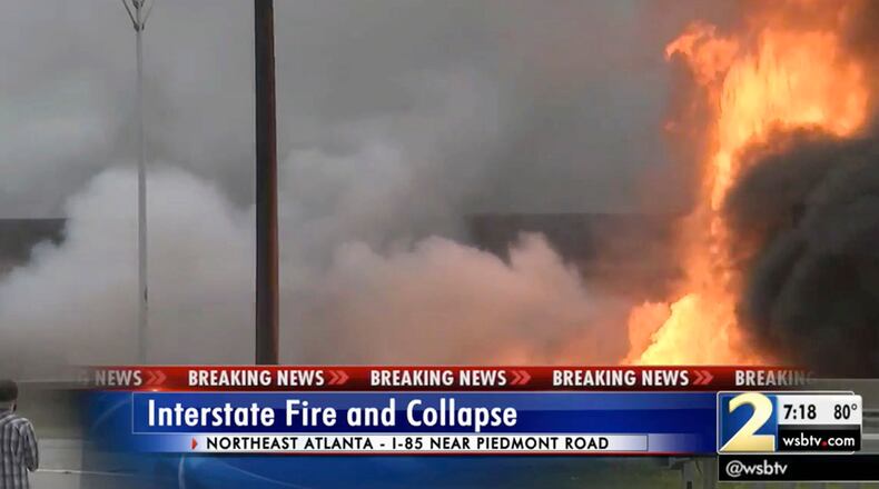In this image made from a video provided by WSB-TV, people watch a large fire, which caused an overpass on Interstate 85 to collapse, burn in Atlanta, Thursday, March 30, 2017. Witnesses say troopers were telling cars to turn around on the bridge because they were concerned about its integrity. Minutes later, the bridge collapsed. (WSB-TV via AP)