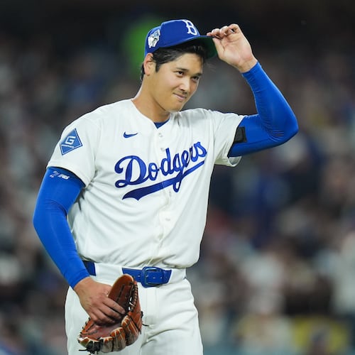 Los Angeles Dodgers starting pitcher Shohei Ohtani adjusts his hat as he walks off the field after the third inning of a baseball game against the New York Mets Wednesday, April 15, 2026, in Los Angeles. (AP Photo/Jae C. Hong)
