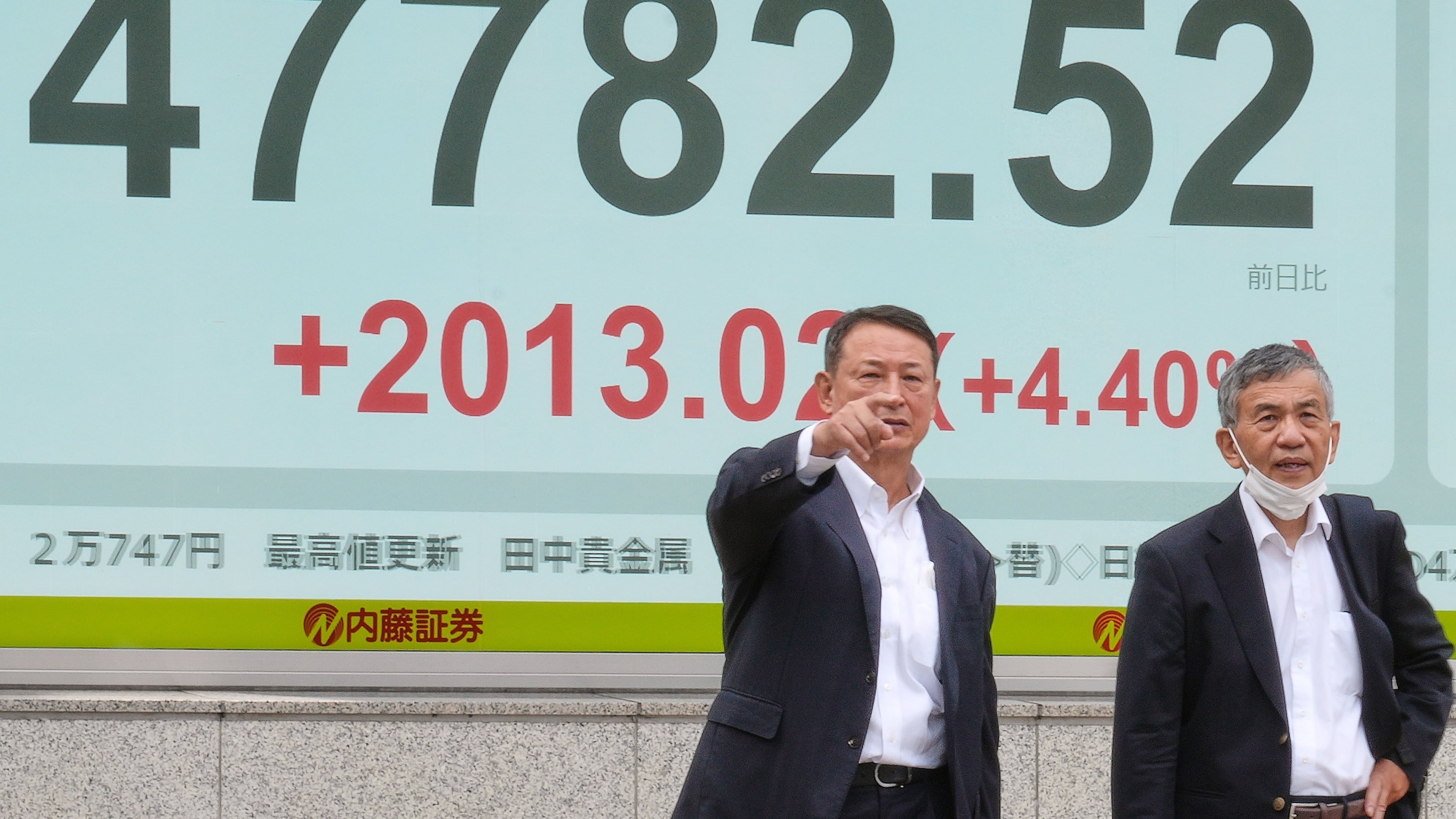 People stand in front of an electronic stock board showing Japan's Nikkei index at a securities firm Monday, Oct. 6, 2025, in Tokyo. (AP Photo/Eugene Hoshiko)