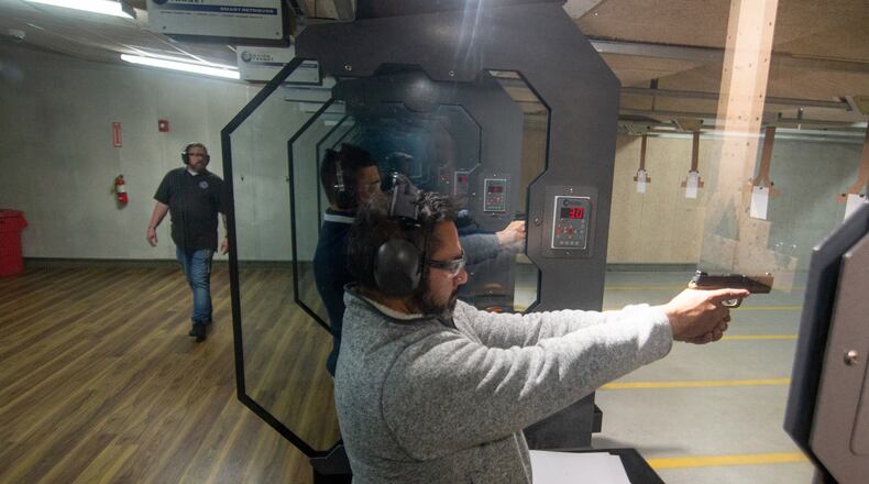 Mark Cano fires his handgun at the range as instructor Kyle Klyncko looks on during a Saturday morning handgun training class at Georgia Gun Club in Buford on January 23, 2021.  STEVE SCHAEFER FOR THE ATLANTA JOURNAL-CONSTITUTION