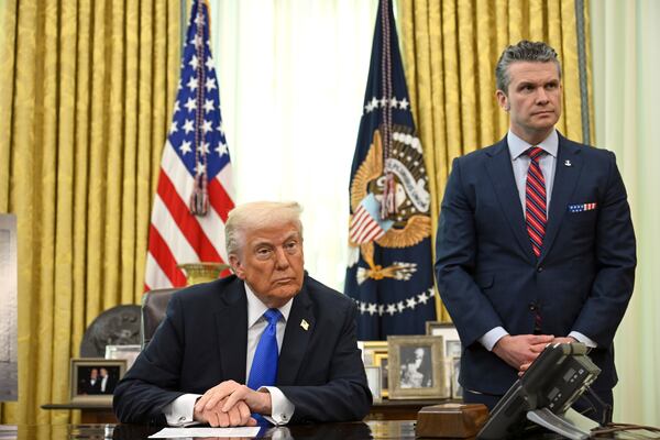 President Donald Trump, left, and Secretary of Defense Pete Hegseth listen during an event in the Oval Office of the White House in Washington, Friday, March 21, 2025. (Pool via AP)