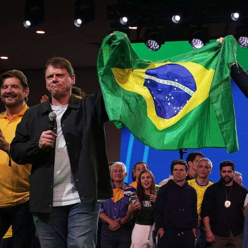 Brazilian Sen. Flavio Bolsonaro, right, and Sao Paulo Gov. Tarcisio de Freitas hold up their country's national flag during the Liberal Party convention where Bolsonaro was confirmed as the party's presidential candidate in Sao Paulo, Saturday, July 25, 2026. (AP Photo/Ettore Chiereguini)