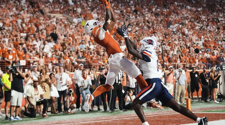 Texas wide receiver Cam Coleman, left, catches a touchdown pass as UTSA cornerback RJ Lester Jr., right, defends during the first half of an NCAA college football game in Austin, Texas, Saturday, Sept. 19, 2026. (AP Photo/Eric Gay)