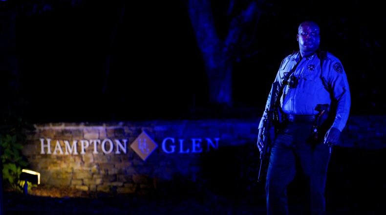 A Cobb County deputy walked around armed in front of the Hampton Glen subdivision off Irwin road after two deputies were killed Thursday evening serving a warrant. (Ben Hendren for The Atlanta Journal-Constitution)