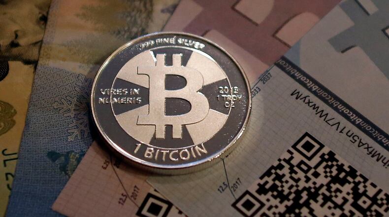 One of Bitcoin enthusiast Mike Caldwell's coins in this photo illustration at his office in Sandy, Utah, from September 17, 2013. The price of the digital currency bitcoin soared above $1,000 for the first time on November 27, 2013, extending a surge this month after a U.S. Senate hearing on virtual currencies.