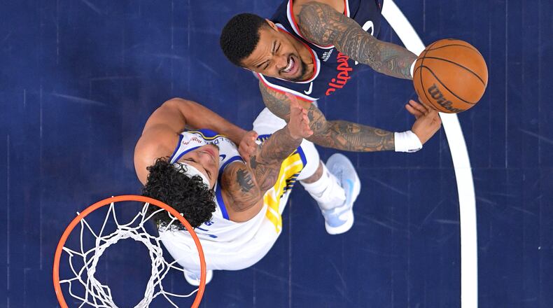 FILE - LA Clippers forward John Collins, right, shoots as Golden State Warriors forward Gui Santos defends during the first half of an NBA play-in tournament basketball game April 15, 2026, in Inglewood, Calif. (AP Photo/Mark J. Terrill, File)