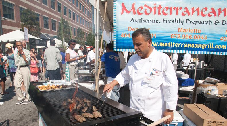 Mediterranean Grill General Manager Emad Deeb sizzles up some chicken and beef dishes on an open flame grill Saturday Oct. 6, 2012 at the Taste of Atlanta.