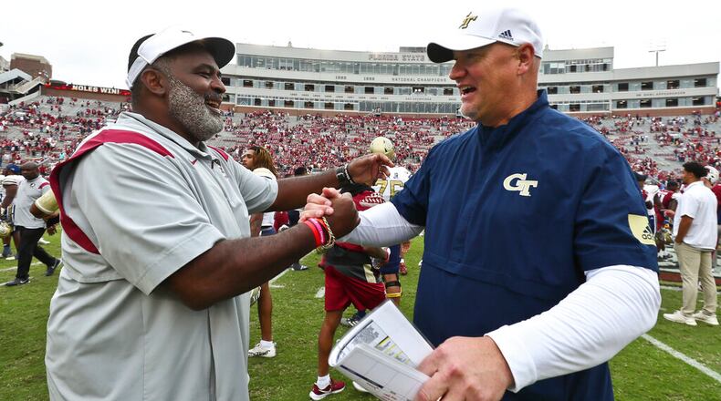 Florida State associate head coach/defensive tackles coach Odell Haggins, left, shakes hands with Georgia Tech quarterbacks coach Chris Weinke after of an NCAA college football game Saturday, Oct. 29, 2022, in Tallahassee, Fla. Weinke was the Heisman Trophy-winning quarterback for Florida State in 2000. Florida State won 41-16. (AP Photo/Phil Sears)