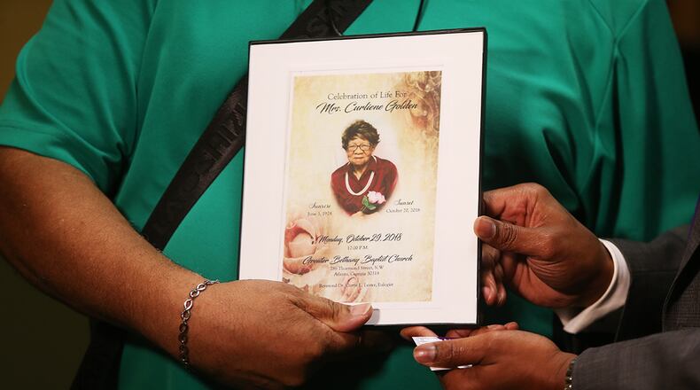John Golden holds up the funeral program for his mother, Curliene Golden, at a press conference in July, in Jonesboro. He and his attorney suspect that she was sexually assaulted at Governor's Glen Assisted Living Facility in Clayton County. She died weeks later. (Christina Matacotta/Christina.Matacotta@ajc.com)