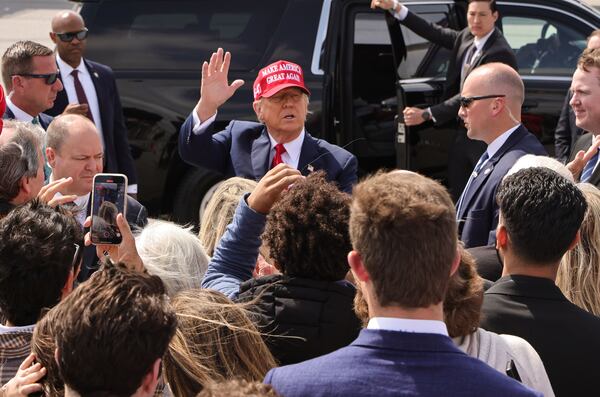 Former President Donald Trump greets supporters after arriving at Hartsfield-Jackson International Airport.