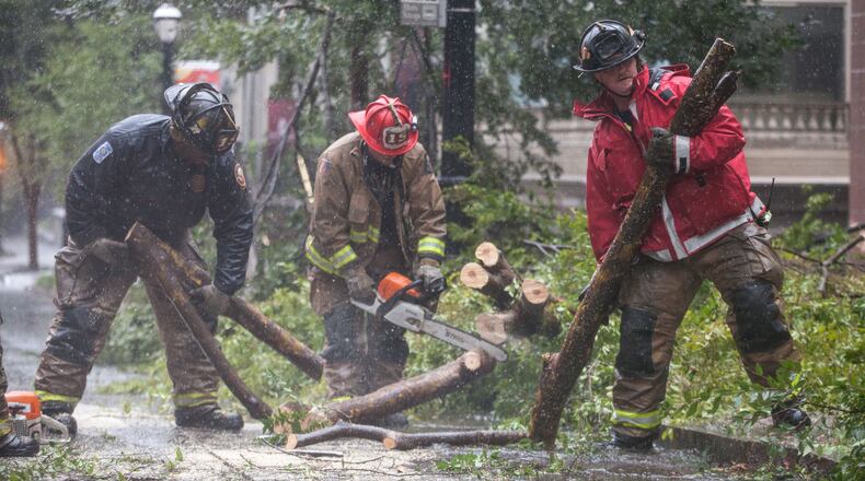 Atlanta firefighters work to clear a downed tree on 14th Street near Peachtree Street in downtown Atlanta, Monday, Sept. 11, 2017.  BRANDEN CAMP/SPECIAL