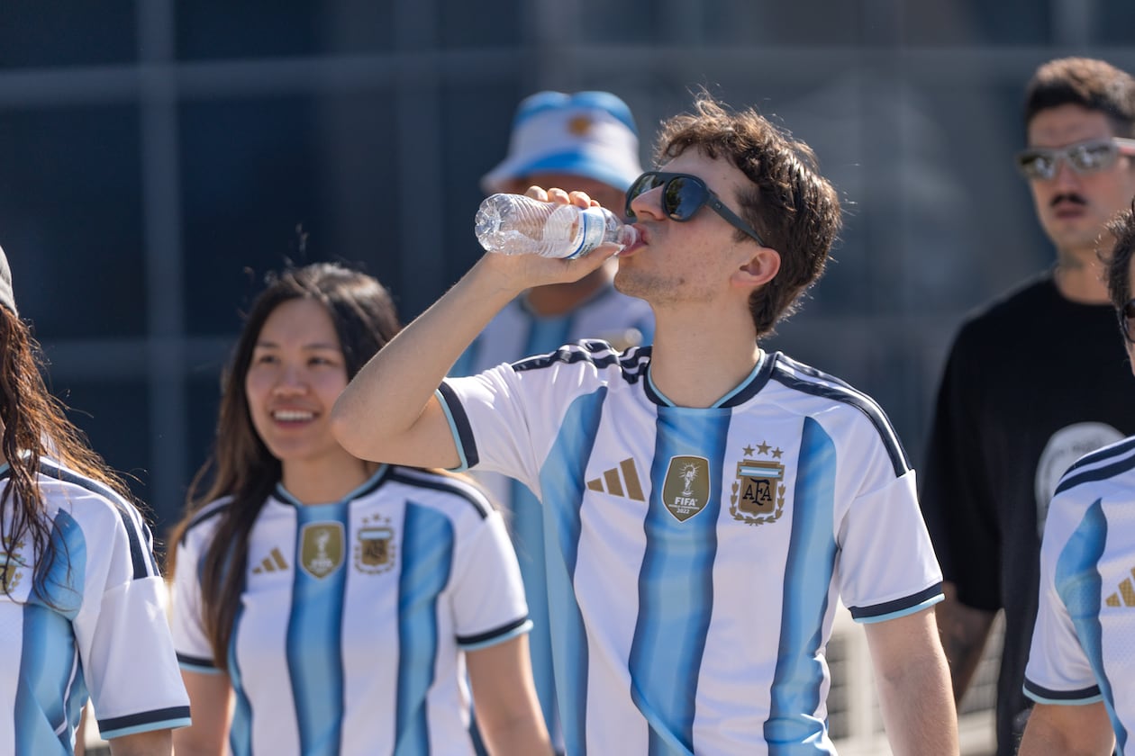 A man in a Argentina jersey drinks water outside of Atlanta stadium ahead of the Argentina versus Egypt World Cup game on July 7, 2026. (Ben Hendren for the AJC)