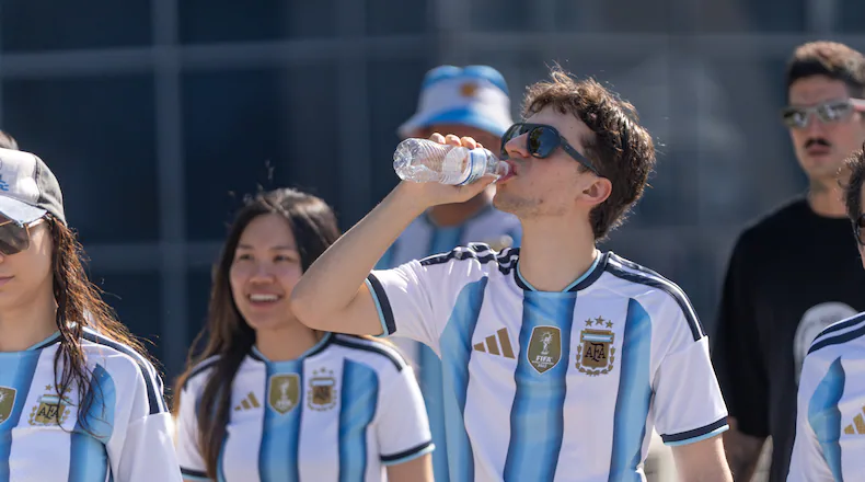 A man in a Argentina jersey drinks water outside of Atlanta stadium ahead of the Argentina versus Egypt World Cup game on July 7, 2026. (Ben Hendren for the AJC)