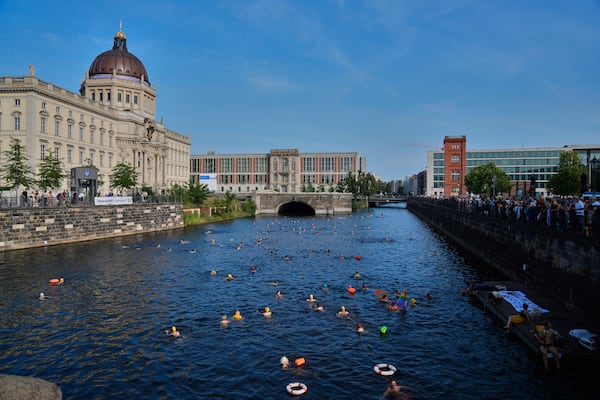 People swim in the river Spree to demand the lift of the hundred years old swimming ban at the river in front of the Stadtschloss or City Place in Berlin, Germany, Tuesday, June 17, 2025. (AP Photo/Markus Schreiber)