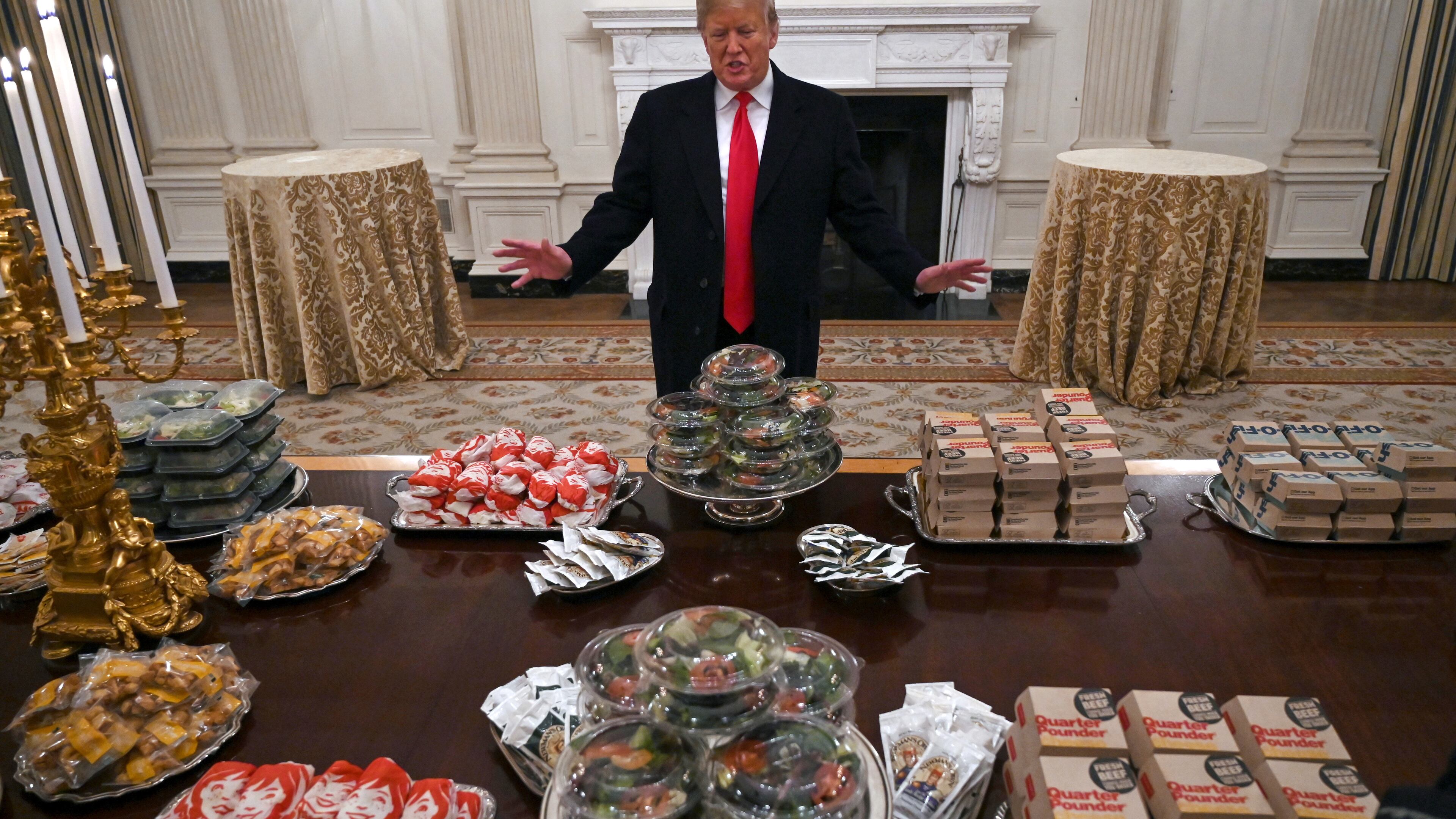 FILE - President Donald Trump talks to reporters about the table full of fast food in the State Dining Room of the White House in Washington, Jan. 14, 2019, for the reception for the Clemson Tigers. (AP Photo/Susan Walsh)