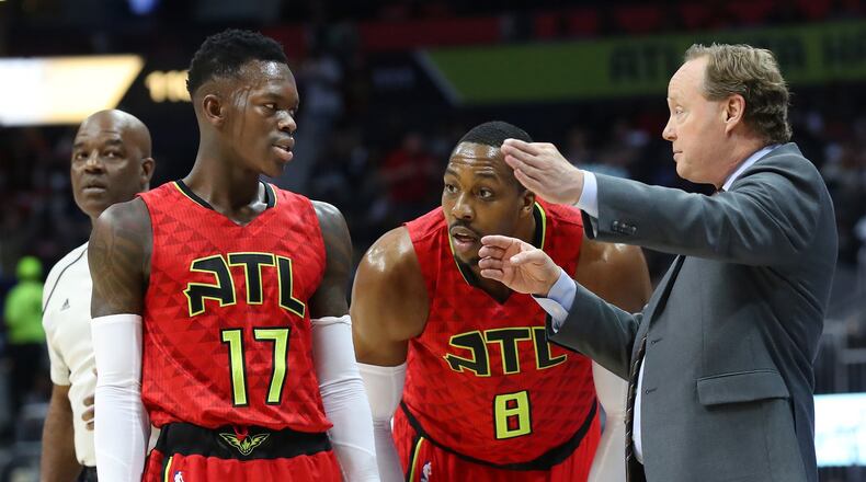 Hawks center Dwight Howard and guard Dennis Schroder confer with coach Mike Budenholzer during a regular-season game on March 26, 2017 in Atlanta. Curtis Compton/ccompton@ajc.com