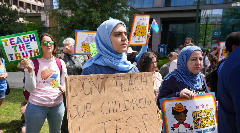 Aasya Peera of Pflugerville holds a sign reading "Don't teach our children lies!" during a rally on the Capitol Mall outside the Barbara Jordan State Office Building, where the State Board of Education meets, Tuesday, April 7, 2026, in Austin, Texas. (Jay Janner/Austin American-Statesman via AP)
