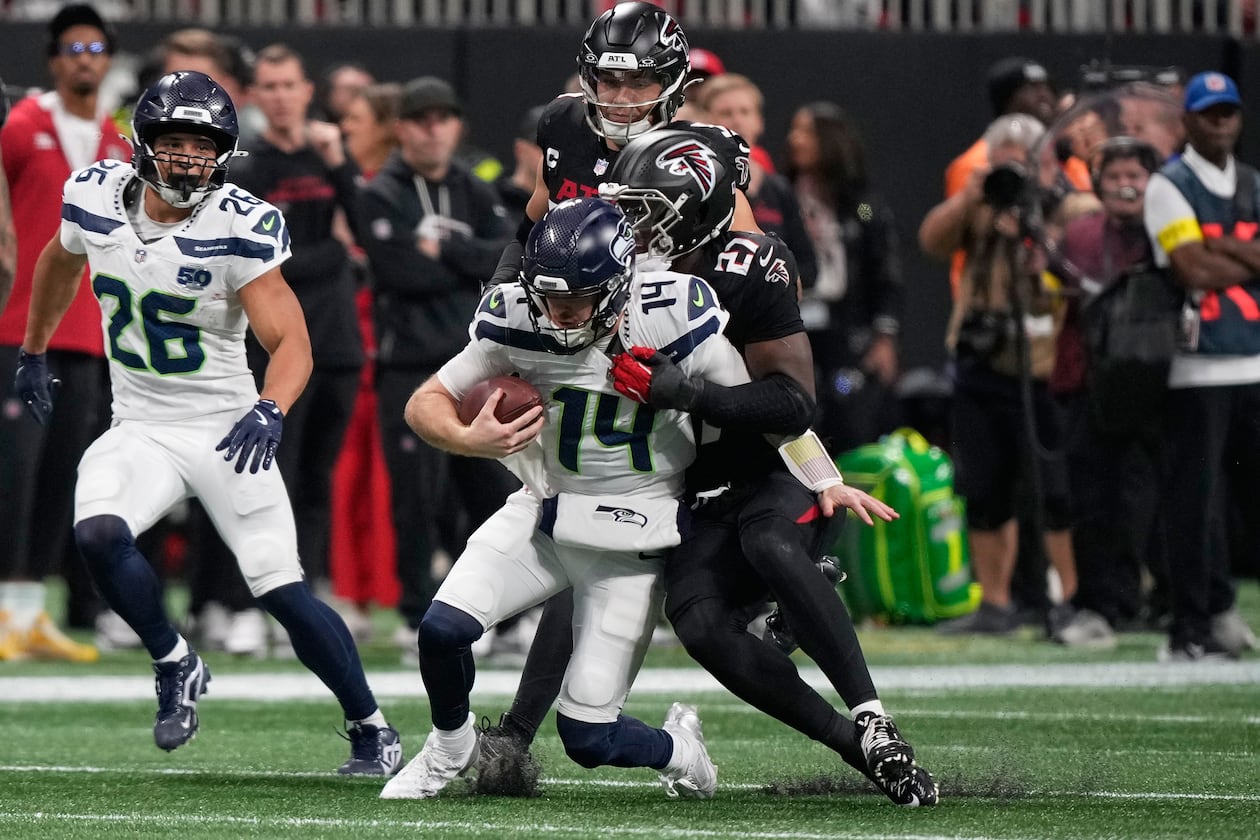 Atlanta Falcons linebacker James Pearce Jr. tackles Seattle Seahawks quarterback Sam Darnold (center) during the first half of an NFL football game, Sunday, Dec. 7, 2025, in Atlanta. (Brynn Anderson/AP)