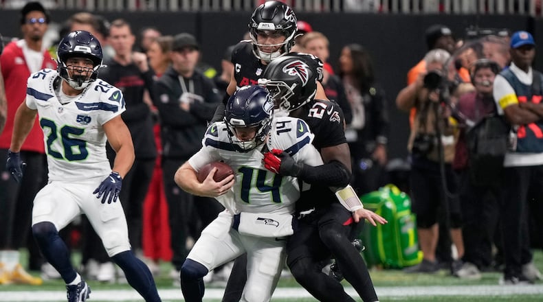 Atlanta Falcons linebacker James Pearce Jr. tackles Seattle Seahawks quarterback Sam Darnold (center) during the first half of an NFL football game, Sunday, Dec. 7, 2025, in Atlanta. (Brynn Anderson/AP)