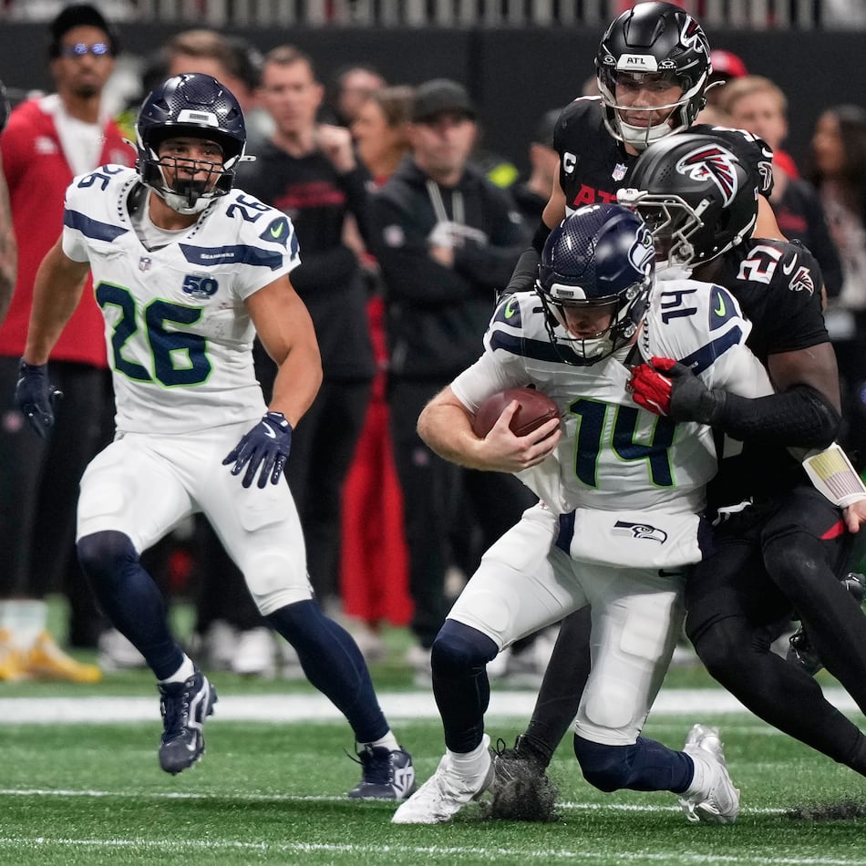 Atlanta Falcons linebacker James Pearce Jr. tackles Seattle Seahawks quarterback Sam Darnold (center) during the first half of an NFL football game, Sunday, Dec. 7, 2025, in Atlanta. (Brynn Anderson/AP)
