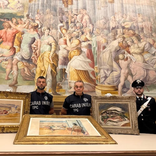 In this picture made available by the Italian Carabinieri in Parma, northern Italy, Friday, Aug. 14, 2026, Carabinieri pose near three paintings recovered following a police operation: "Tasse et plat de cerises" by Paul Cezanne, left, "Odalisque Sur La Terrasse" by Henri Matisse, center, and "Les Poissons" by Pierre Auguste Renoir, right. (Italian Carabinieri via AP)