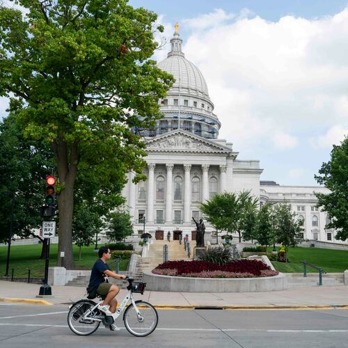 FILE - A cyclist rides past the Wisconsin State Capitol on July 30, 2024, in Madison, Wis. (AP Photo/Kayla Wolf, File)