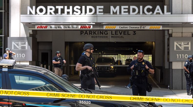 Law enforcement officers are seen on West Peachtree Street in front of Northside Hospital Midtown medical office building, where five people were shot Wednesday, May 3, 2023. One person died. (Arvin Temkar/The Atlanta Journal-Constitution/TNS)