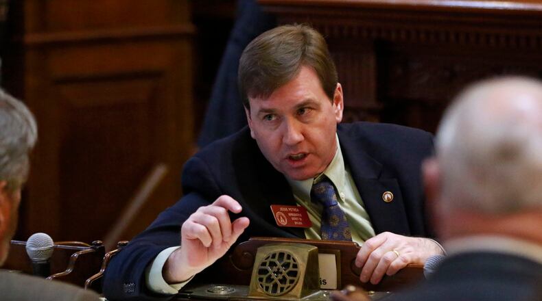 State Rep. Jesse Petrea, R-Savannah, confers with others on the floor of the Georgia House. He’s the author of House Bill 657, which would make it illegal for a person to “knowingly and intentionally” provide a firearm to someone convicted of a felony. BOB ANDRES / BANDRES@AJC.COM