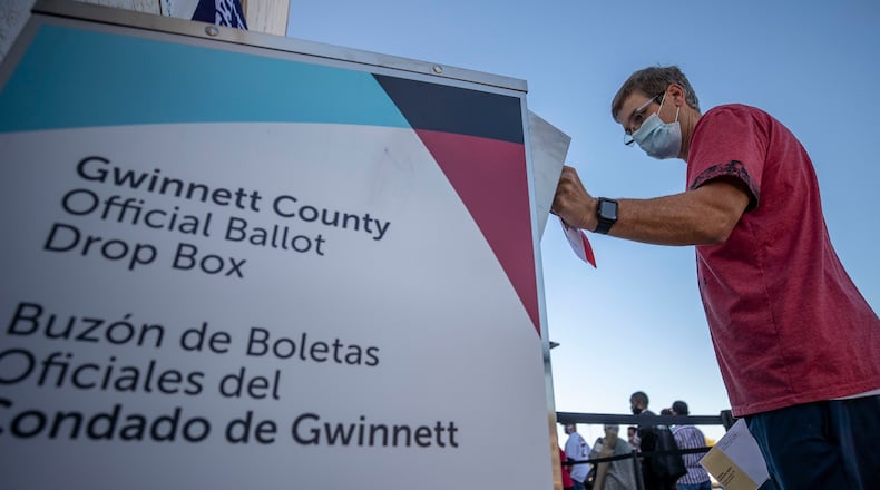 A voter places his absentee ballot inside a drop box on the second day of early voting at the Gwinnett County Voter Registration and Elections building on Oct. 13, 2020, in Lawrenceville, Georgia. An auditor from Gwinnett County, Mark Andrews, who was falsely accused of election fraud in the film "2000 Mules" later filed a defamation lawsuit against the movies makers, Dinesh D'Souza and True the Vote, alleging they lied to advance a phony narrative at his expense. (File photo by Alyssa Pointer/Atlanta Journal-Constitution/TNS)