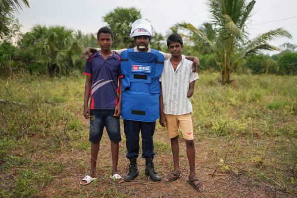 Vilvaraj Vinothan, center, who works for a demining agency, poses with his younger brothers Kumarakulasingham Dinojan, right, and Vilvaraj Jethurshan, both injured in a land mine explosion, in Mankindi, Sri Lanka, Tuesday, April 1, 2025. (AP Photo/Eranga Jayawardena)